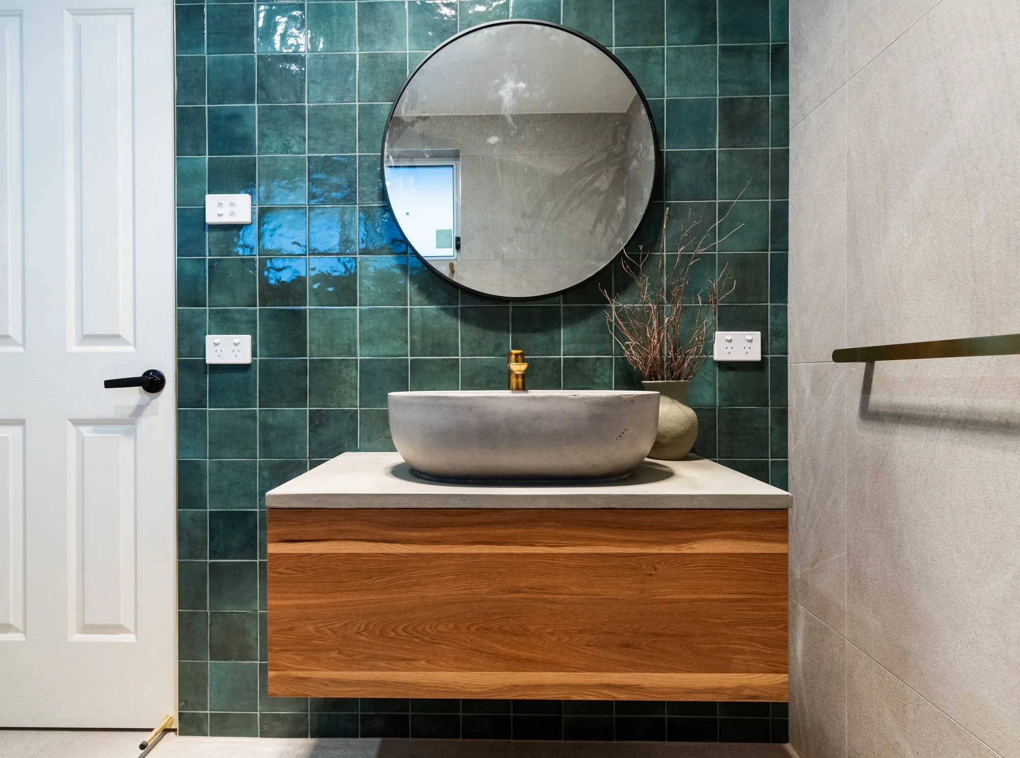 Timber vanity with dark green feature tiles