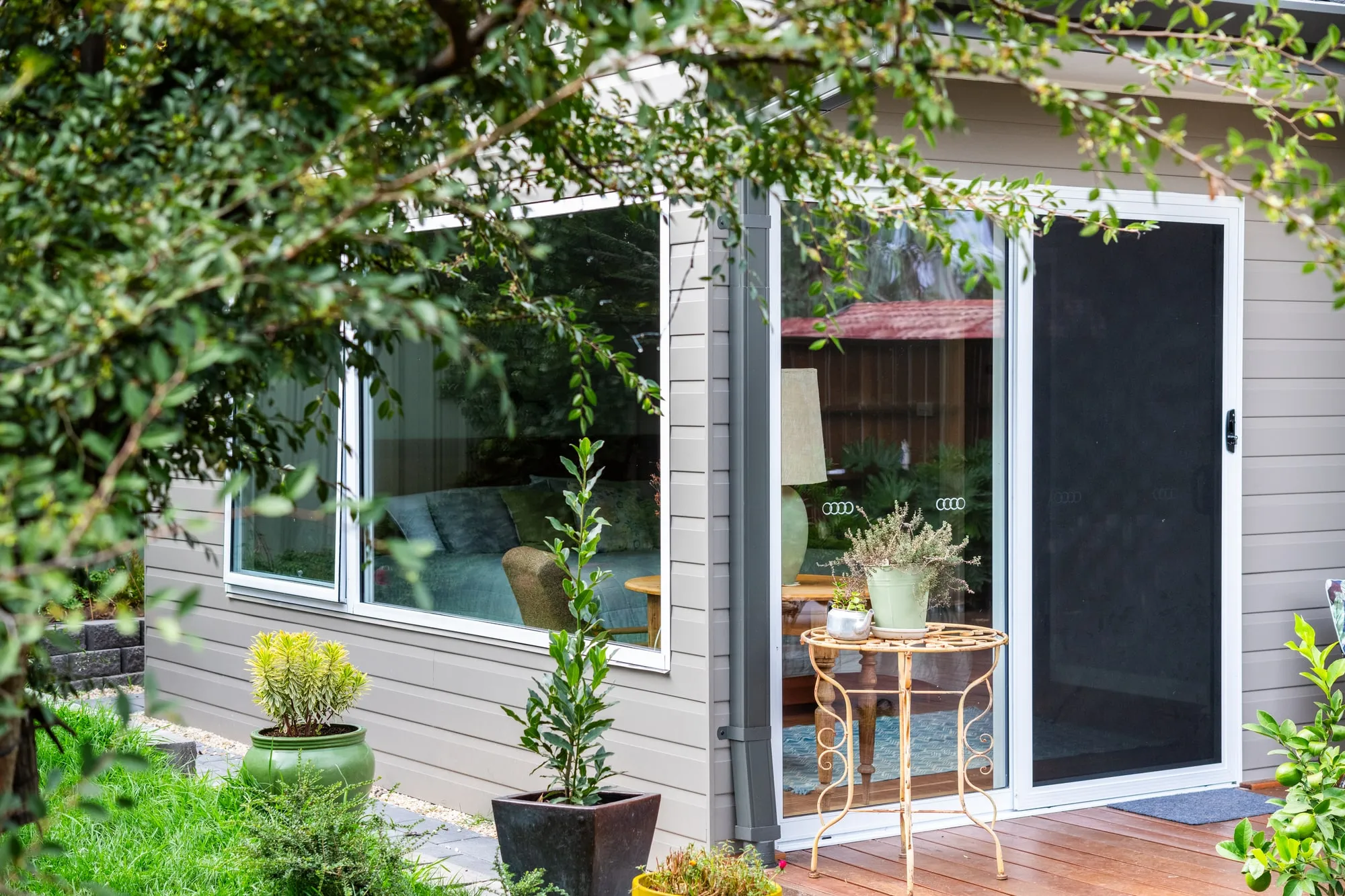 Building exterior showing timber cladding, large picture windows and sliding door to deck