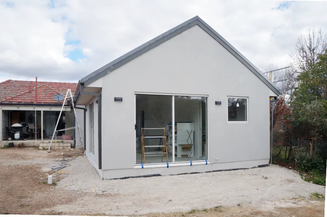 Rear of extension nearing the completion of construction. Show steep roof pitch and sliding door into the master bedroom