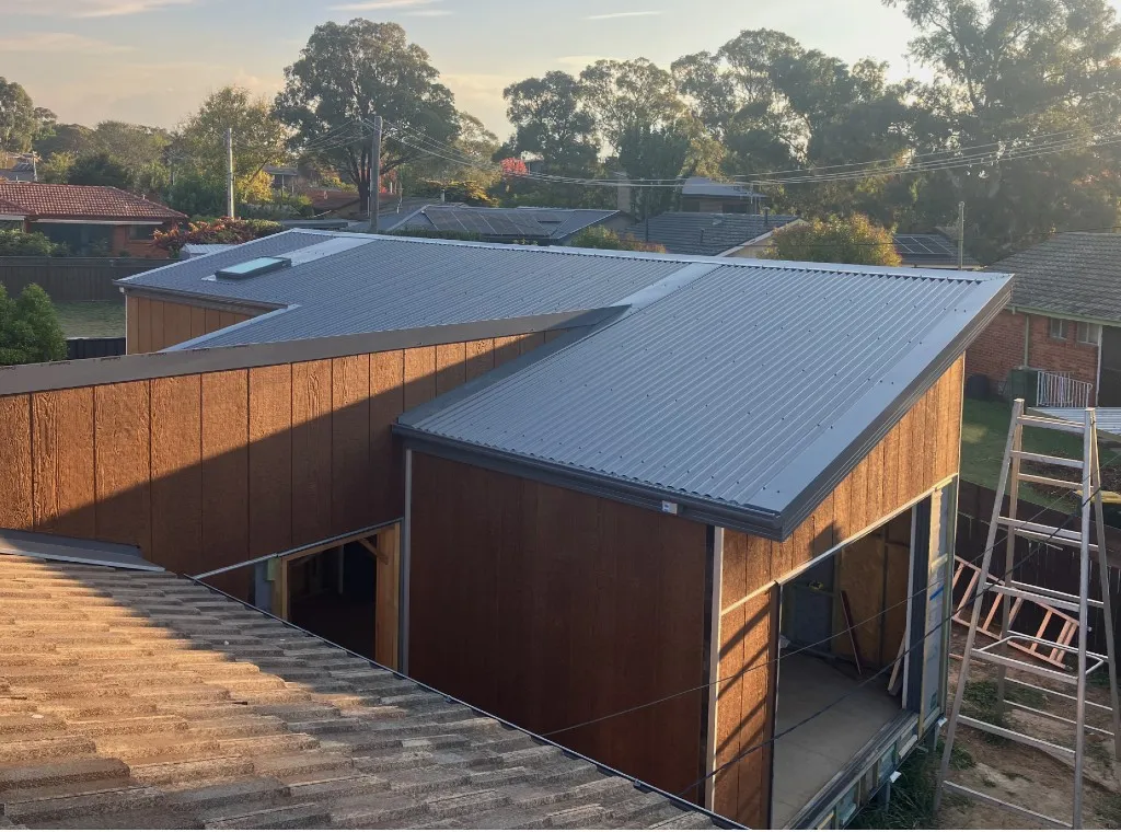 Extension with new timber-look cladding and a dark metal skillion roof, seen from above