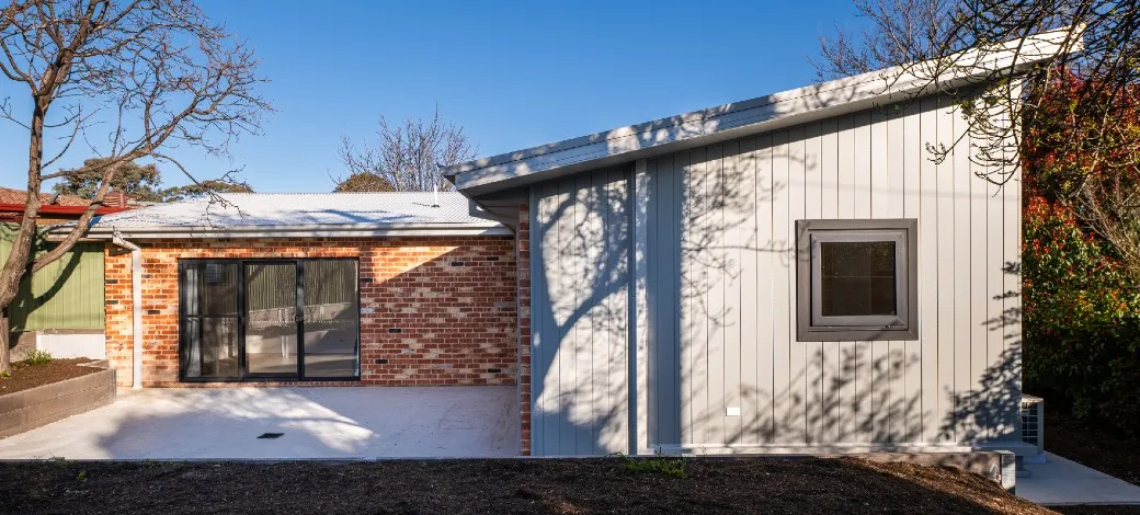Exterior showing walls featuring recycled bricks and light grey cladding