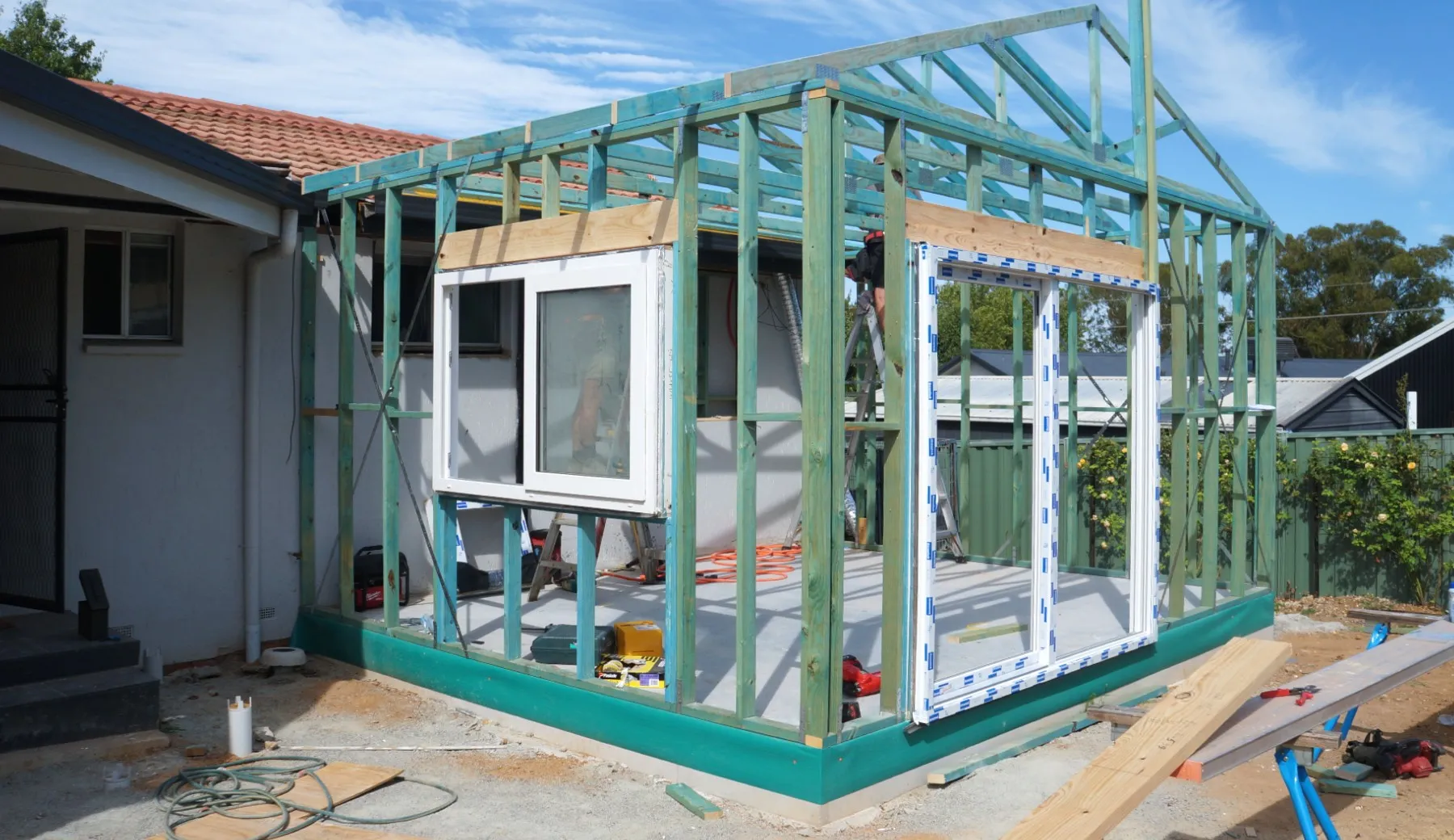 Construction site showing slab and timber framing of a small bedroom addition