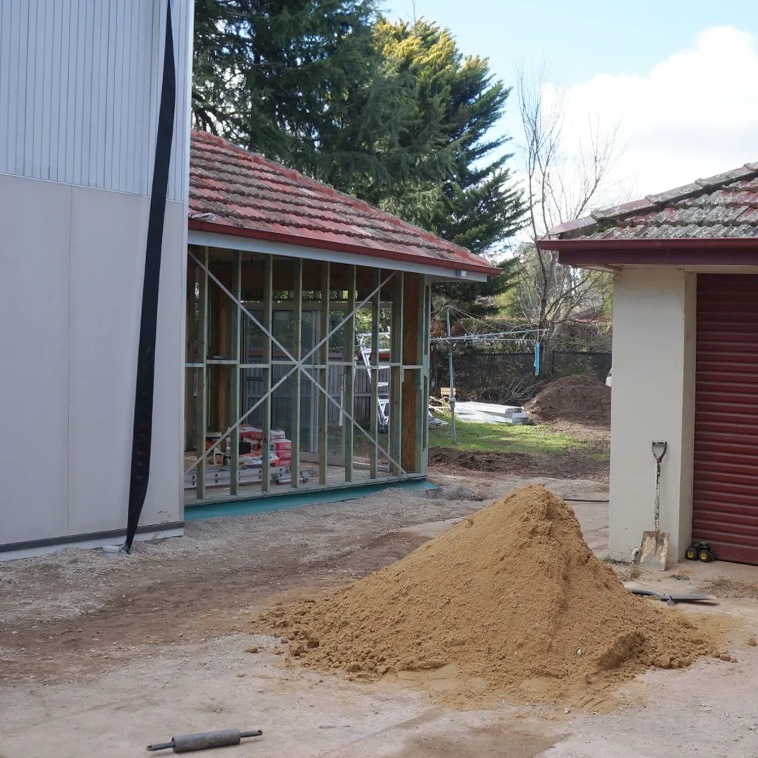 A clean building site with a pile of sand
