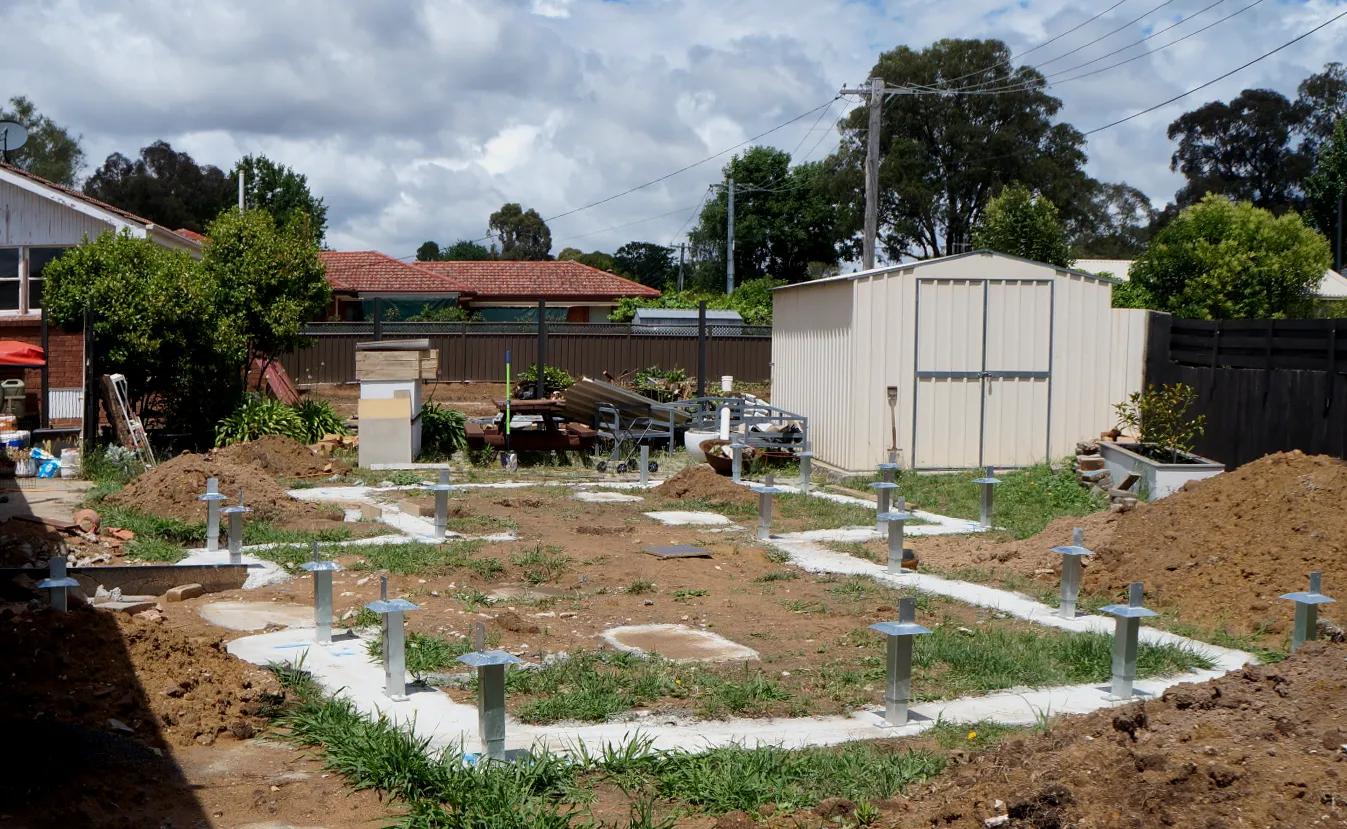 Construction site showing concrete strip footings and peers fitted.